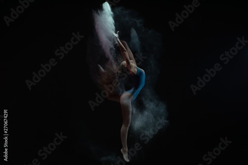 Fototapeta Naklejka Na Ścianę i Meble -  Graceful gtrl dancing in dust cloud profile view
