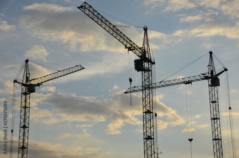 Construction crane near the building under construction. Close up of a construction crane. Self-erection crane. Construction site