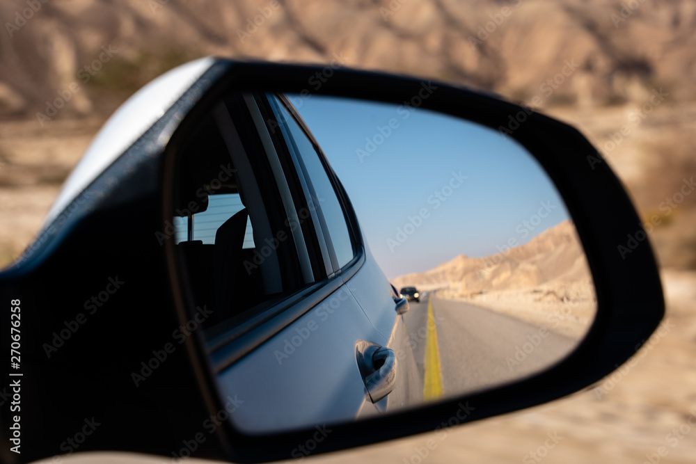 street, desert and car seen from the rearview mirror