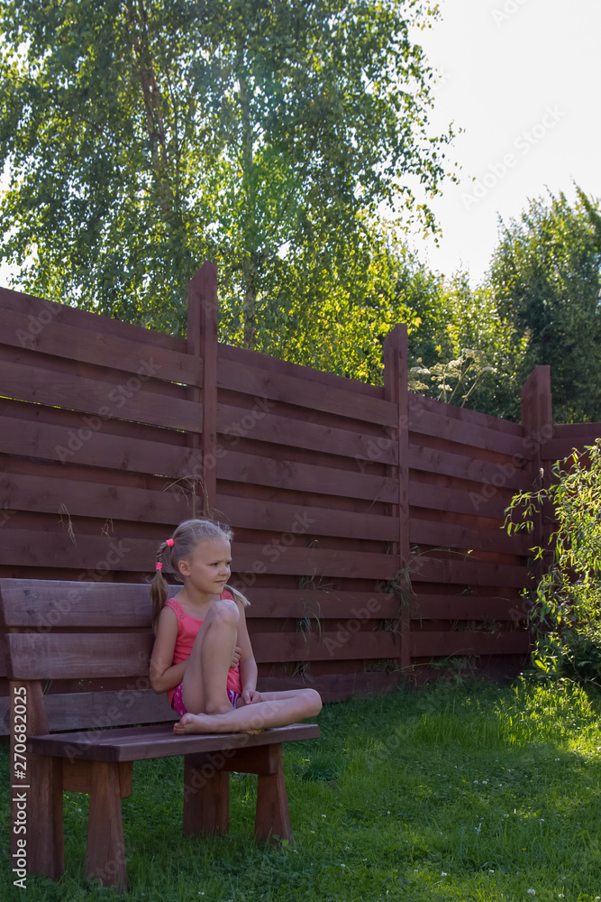 thoughtful girl sitting on wooden bench thoughtful girl sitting on wooden bench