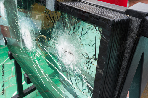 The bulletproof glass after the test, cracks and dents on the window from the bullet at the exhibition of weapons photo