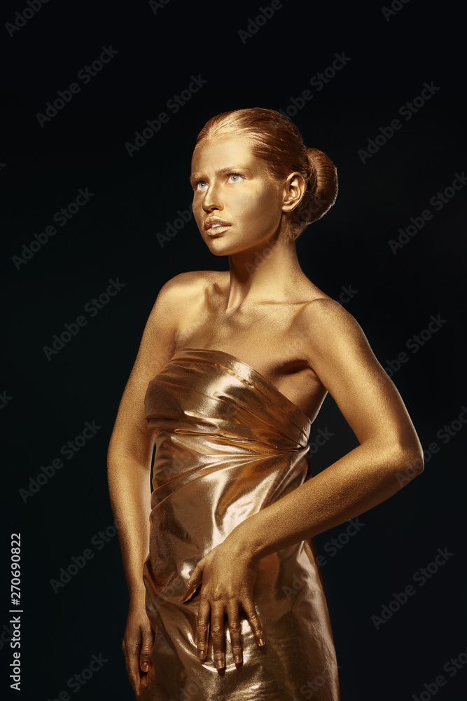 Portrait of beautiful lady with gold paint on skin against black background Portrait of beautiful lady with gold paint on skin against black background