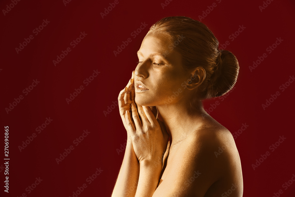 Portrait of beautiful lady with gold paint on skin against color background Portrait of beautiful lady with gold paint on skin against color background