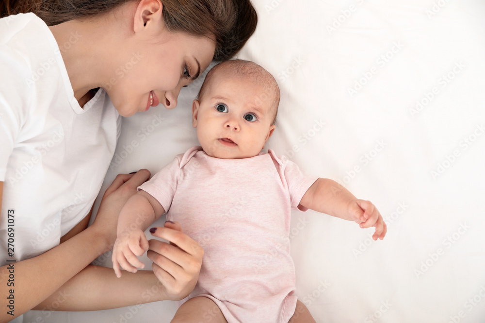 Portrait of mother with her cute baby lying on bed, top view Portrait of mother with her cute baby lying on bed, top view