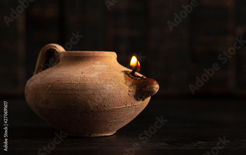 Canvastavla A Lit Handmade Oil Lamp from the Middle East on a Dark Table