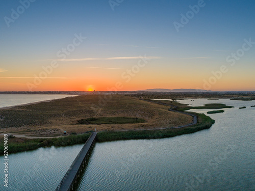 Aerial sunset seascape of Salgados beach and lagoon in Albufeira, Algarve tourism destination region, Portugal.