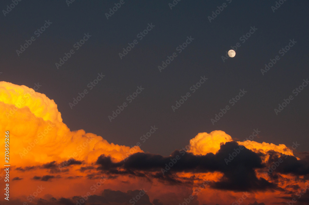 Moon at sunset over beautiful clouds horizontal