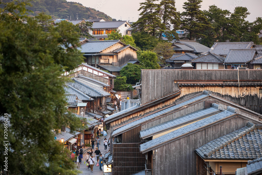 Tourists walk down popular shopping street through traditional wooden buildings in Gion District Tourists walk down popular shopping street through traditional wooden buildings in Gion District