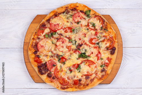 Top view of domestic pizza on white wooden background