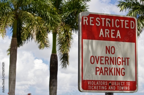 Cuadro en lienzo Restricted Area No overnight Parking Sign Red and white warning sign with palm t