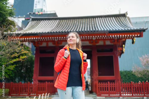 Tokyo, Japan Asakusa area with Sensoji temple shrine with red architecture and happy young tourist woman standing