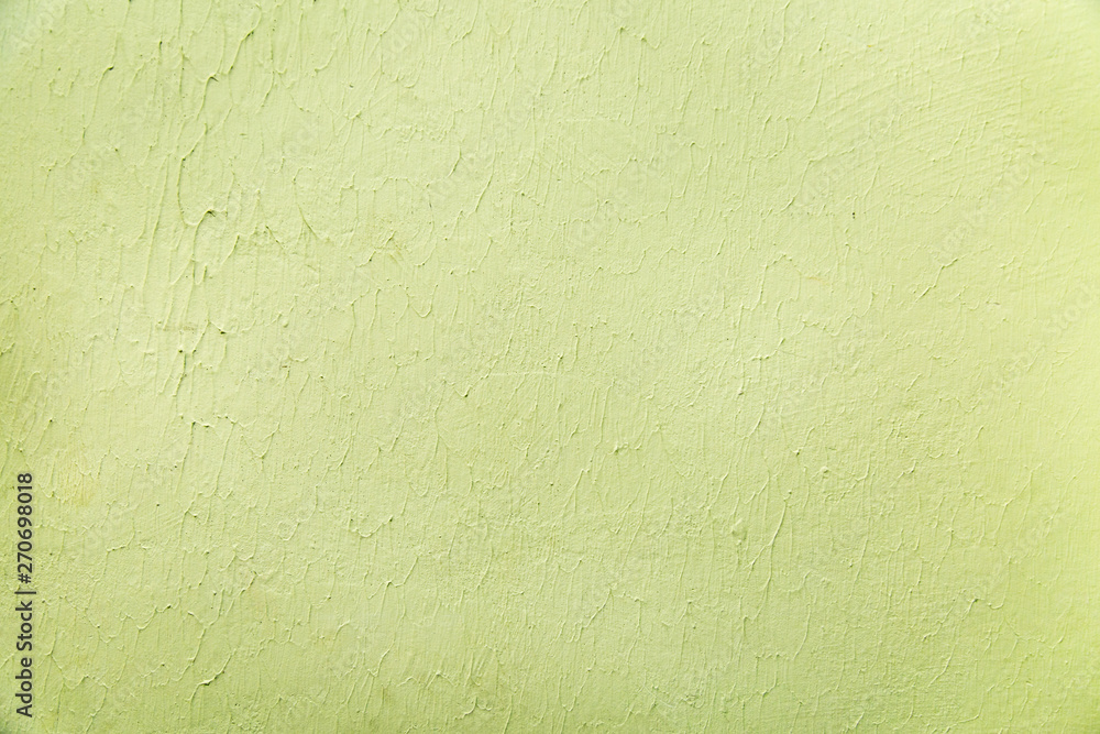 The background of the painted wall with an influx of light green paint. Interior backgrounds textures. The background of the painted wall with an influx of light green paint. Interior backgrounds textures.