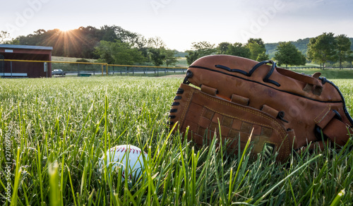Canvas Print Baseball and glove in morning dew green grass