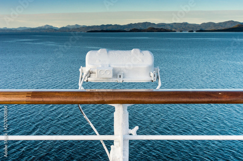 White metal exterior light fixture on railing of cruise ship, Alaska Inside Passage route. photo