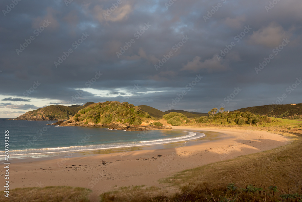 The deserted, sandy beach at Matai Bay in golden, late afternoon light, Karikari Peninsula, Northland, New Zealand. The deserted, sandy beach at Matai Bay in golden, late afternoon light, Karikari Peninsula, Northland, New Zealand.
