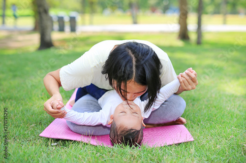 Happy family Asian mom and her son lying on green lawn background.