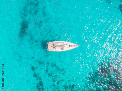 Aerial top view white yacht with sail stands on coral reef in blue transparent turquoise sea. Concept travel © Parilov