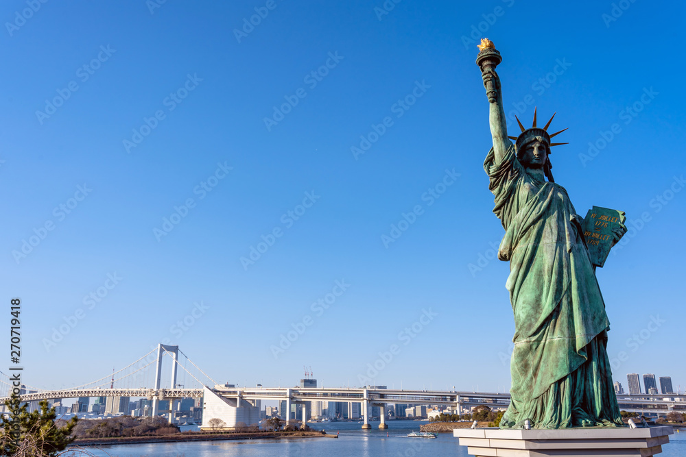 Fototapeta premium Statue of Liberty and Rainbow bridge, located at Odaiba Tokyo, Japan