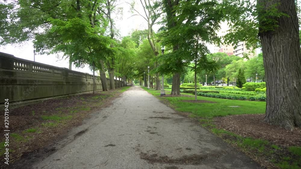 Chicago downtown park pathway during a mid summer afternoon. a very scenic quite garden as the leaves slowly fall from the trees creating a scenic green flow. Chicago downtown park pathway during a mid summer afternoon. a very scenic quite garden as the leaves slowly fall from the trees creating a scenic green flow.