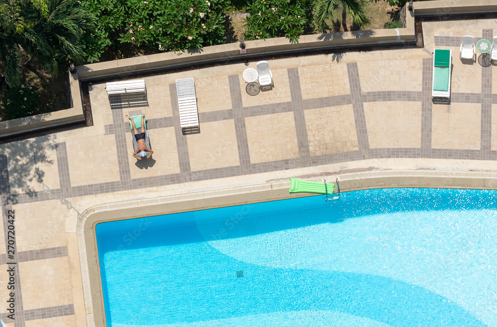 Man relaxing on bed at swimming pool,High angle view.