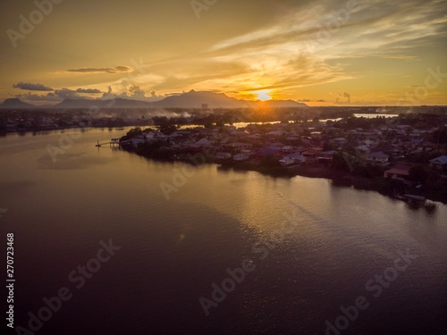 scenic aerial view of Sarawak River during sunset with Gunung (mountain) Serapi at the background © MuhammadFadhli