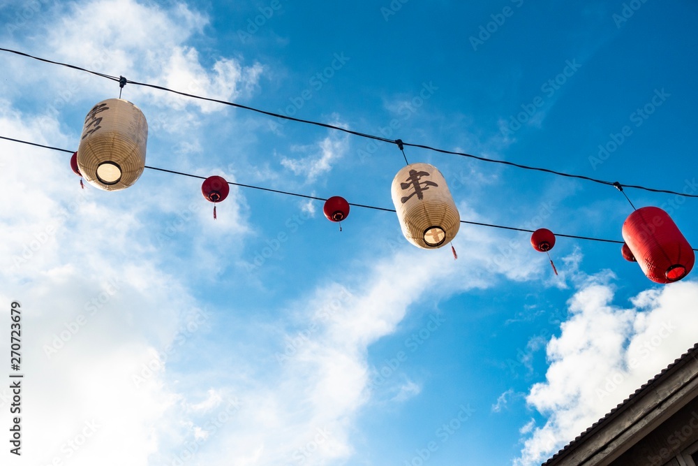 Traditional Chinese Lantern isolated against blue sky. The word on lantern is Ïzakaya Traditional Chinese Lantern isolated against blue sky. The word on lantern is Ïzakaya