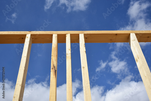 Wood frame residential building under construction.Building construction, wood framing structure at new property development site.new home currently under construction against blue sky.mortgage, loan.