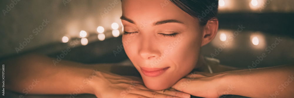 Luxury spa massage woman. Pampering whirlpool jacuzzi lifestyle girl relaxing in hot water banner panorama.