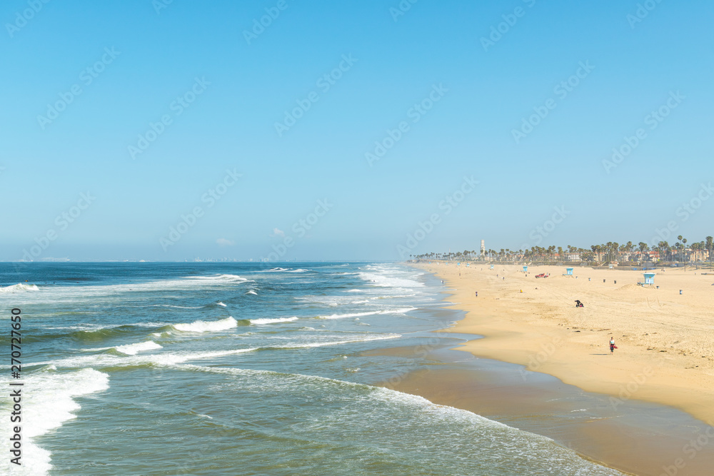 Beach shoreline with waves on sand and blue skies