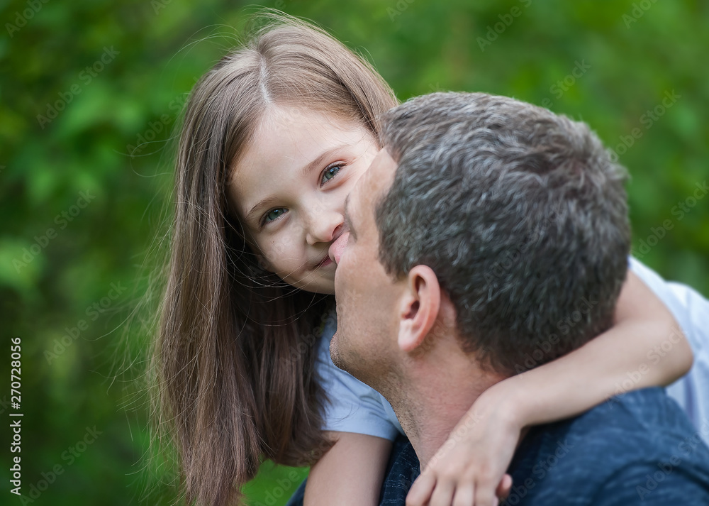 Portrait of cute little girl held in father's arms. Happy loving family. Father and his daughter child girl playing hugging. Cute baby and daddy. Concept of Father day. Family holiday and togetherness Portrait of cute little girl held in father's arms. Happy loving family. Father and his daughter child girl playing hugging. Cute baby and daddy. Concept of Father day. Family holiday and togetherness