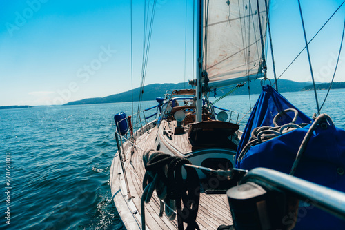 Side profile view of Sailboat while Sailing with Island in the background