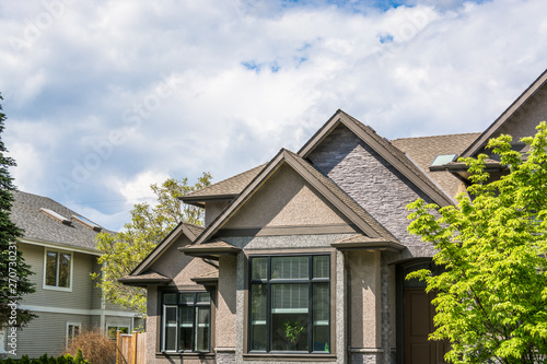 Top of residential house on cloudy sky background