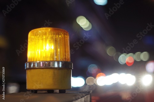Yellow orange siren light rotary warning light in construction side safety sign, installed beside road