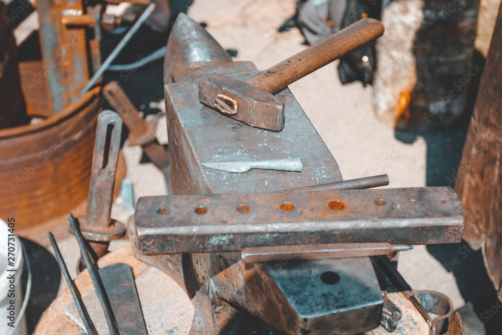 anvil. on it lies a hammer. blacksmith works. close-up. anvil. on it lies a hammer. blacksmith works. close-up.