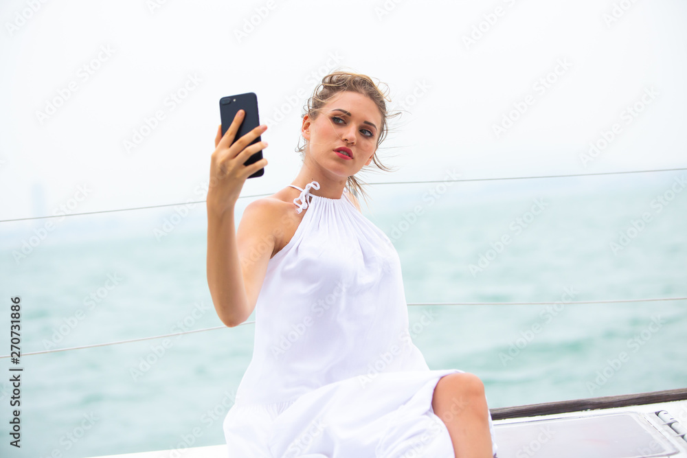 beautiful woman in white dress enjoying luxurious yacht cruise