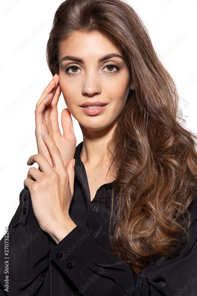Portrait of gorgeous female with long luxury brunette hair. Sweet appearance of charming woman in black shirt. Fashion studio photo. Isolated on grey background Portrait of gorgeous female with long luxury brunette hair. Sweet appearance of charming woman in black shirt. Fashion studio photo. Isolated on grey background