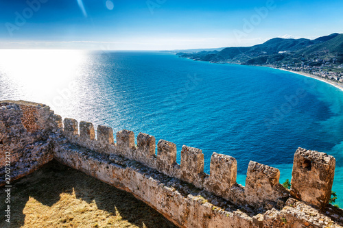 Fototapeta Naklejka Na Ścianę i Meble -  The fortress wall on the background of bright blue sea on a sunny day.
