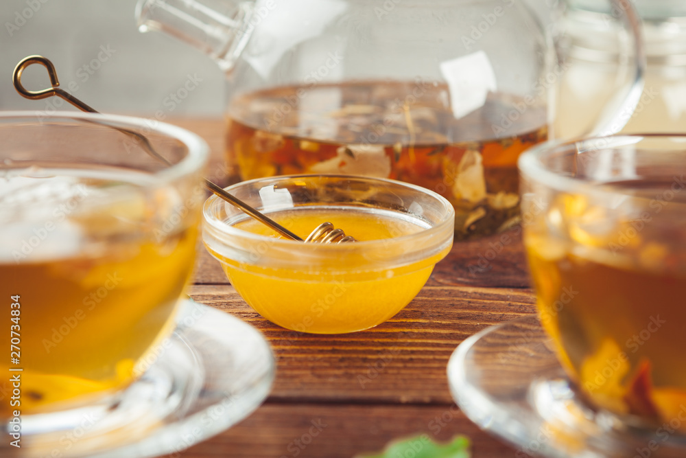 Cup of tea with lemon and honey on wooden background.