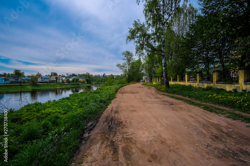 the image in the foreground of a country road and in the distance the visible city of Torzhok, Russia