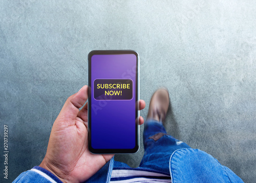 Subscribing and Digital Marketing Concept. Top View of a Man using Smartphone to making Subscribe on his Favorite Channel. Media Content Strategy photo