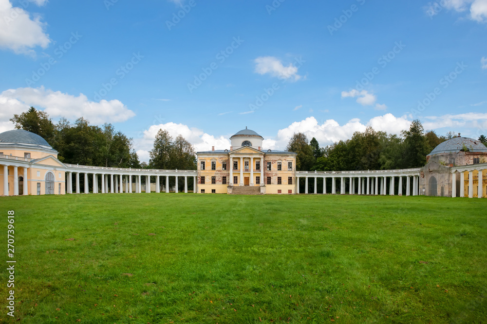 Obraz premium Architectural ensemble Manor Znamenskoye-Rayok. The manor house and the circular colonnade connecting it with the side wings (carriage and greenhouse) and the main gate opposite to it.
