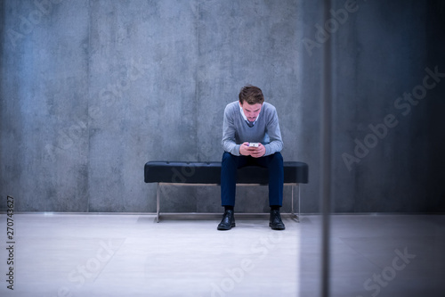 businessman using smart phone while sitting on the bench