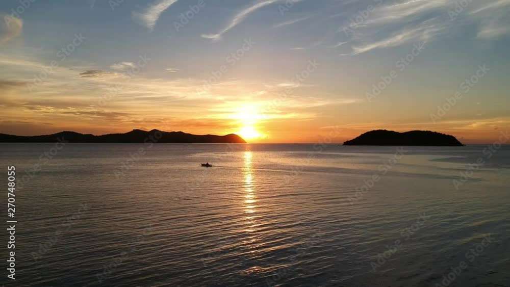 A beautiful sunset with a small boat in the bay, somewhere in Palawan, Philippines A beautiful sunset with a small boat in the bay, somewhere in Palawan, Philippines