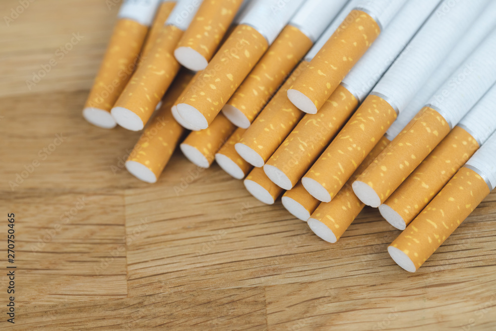 image of several commercially made cigarettes. pile cigarette on wooden. or Non smoking campaign concept, tobacco image of several commercially made cigarettes. pile cigarette on wooden. or Non smoking campaign concept, tobacco