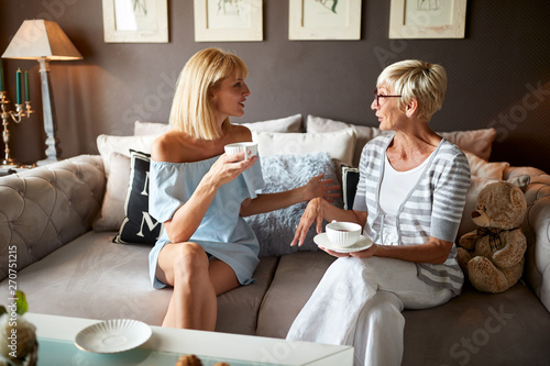 Young and elderly female drinking coffee