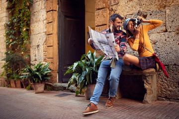 couple with map and photo camera in the city..