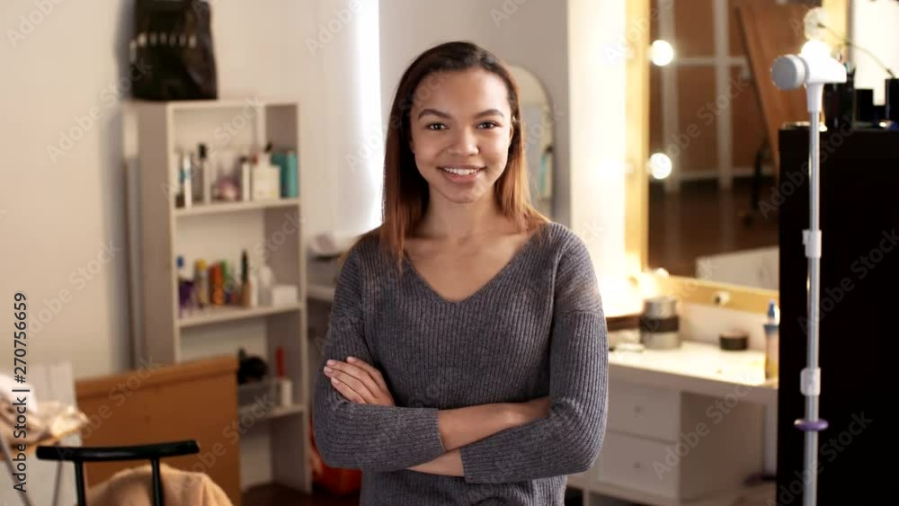 Medium shot of young beautiful African woman standing in her room, crossing hands on her chest while looking at camera and smiling. Suitable for deepfake generation or face swap Medium shot of young beautiful African woman standing in her room, crossing hands on her chest while looking at camera and smiling. Suitable for deepfake generation or face swap