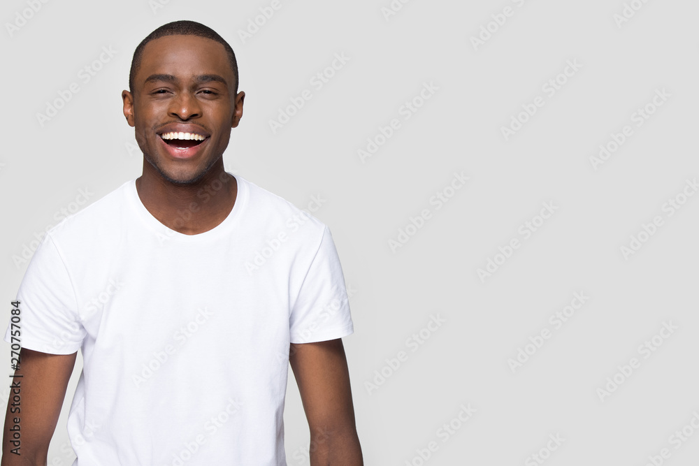 African man laughing looking at camera isolated on grey blank - obrazy, fototapety, plakaty 