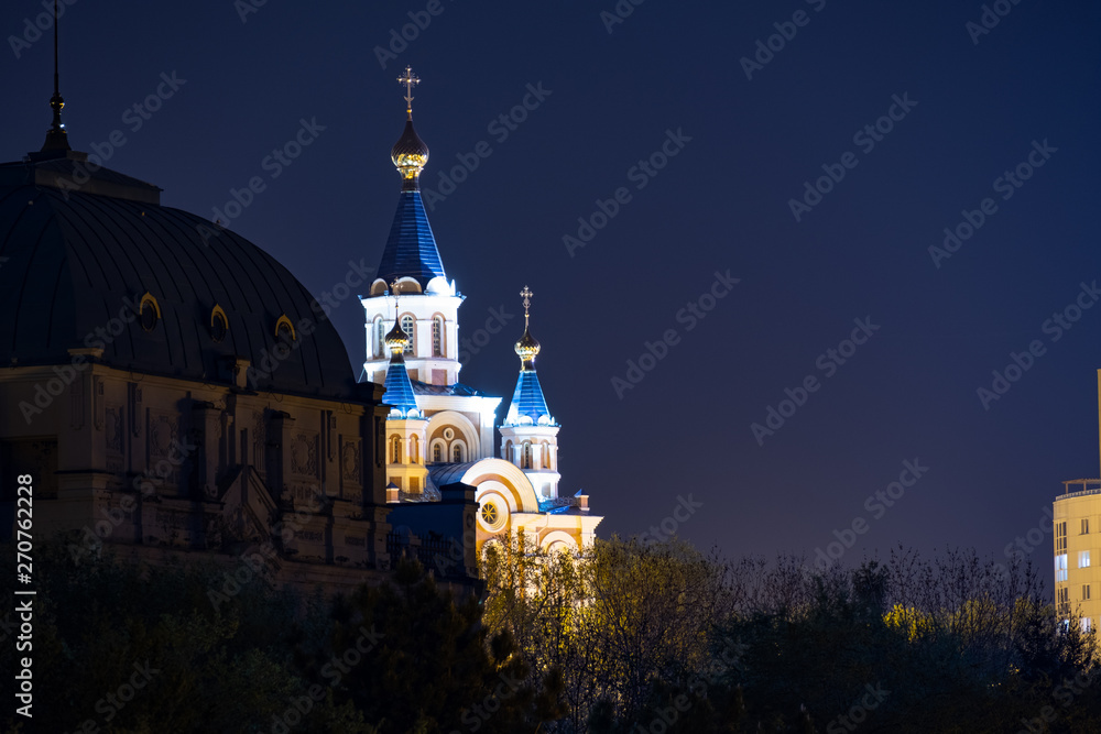 Night View of the city of Khabarovsk from the Amur river. Blue night sky. The night city is brightly lit with lanterns.