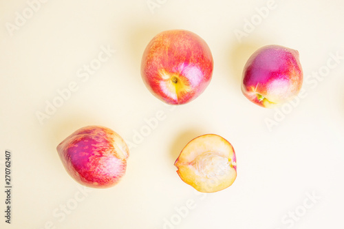 Fresh nectarines on a pastel yellow background. The concept of summer fruits, food rich in vitamins, vegetarianism, veganism. Top view, minimalism, flat lay.